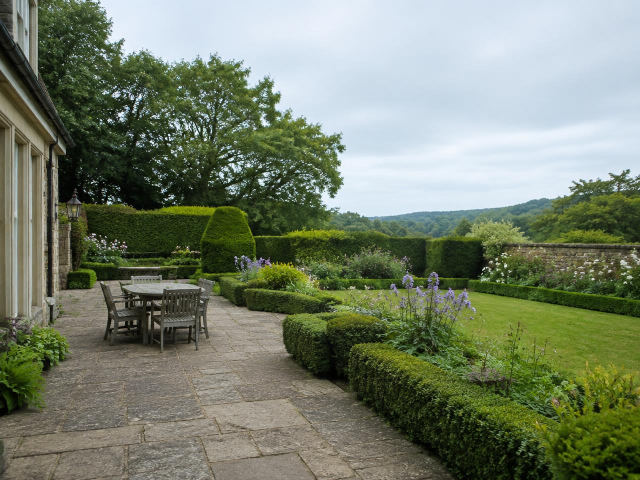 Landscaped garden with stone patio and clipped hedging